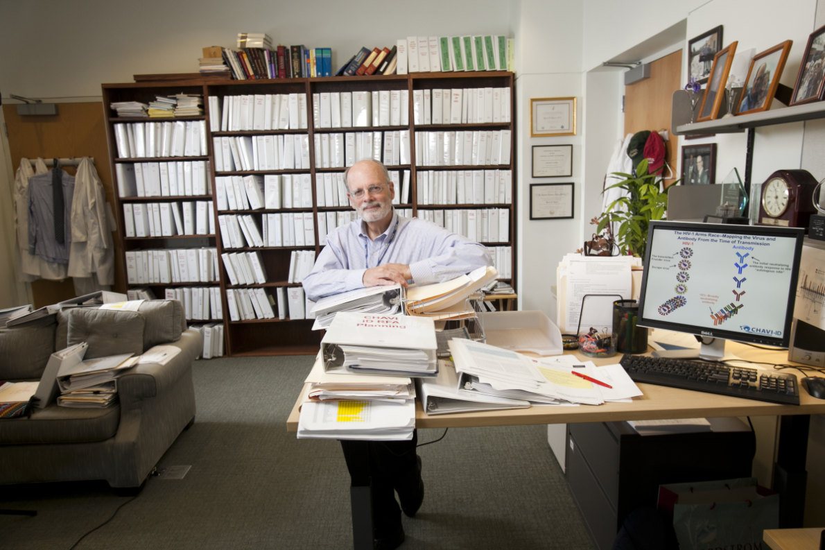 Bart Hayes in his office in front of a wall of white notebooks