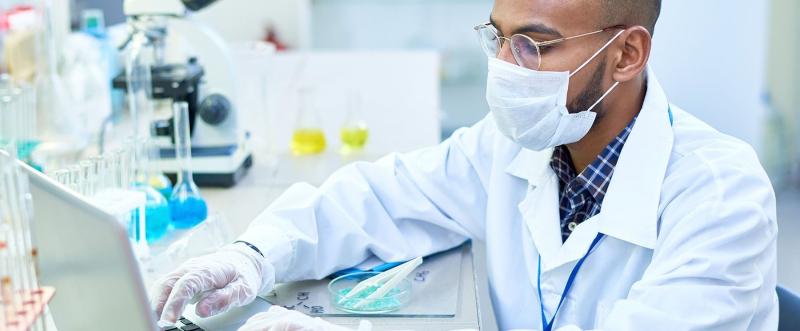 man working in lab wearing a mask