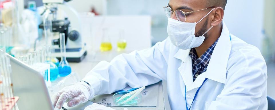 man working in lab wearing a mask